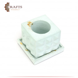 A square cement bowl with raised ridges